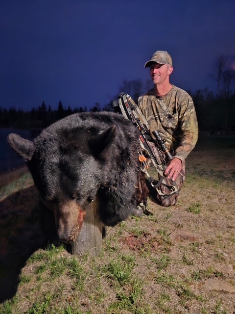 Hunter with harvested black bear at Black Bear Island Lodge