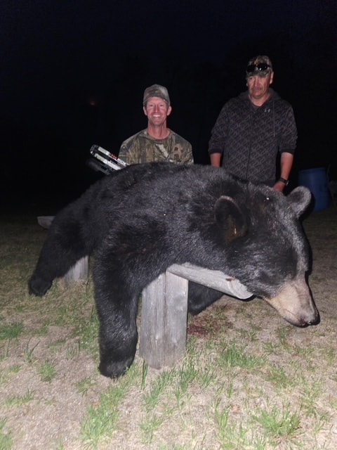 Two hunters posing with harvested black bear at Black Bear Island Lodge