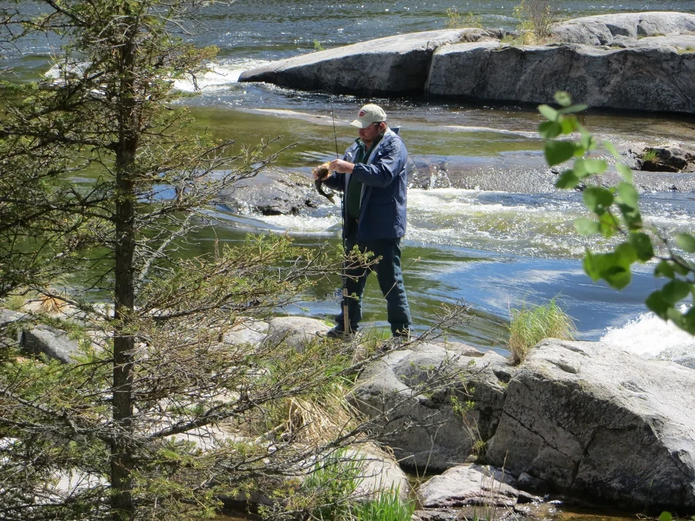 Man fishing at rapids on the Churchill River, scenic action shot