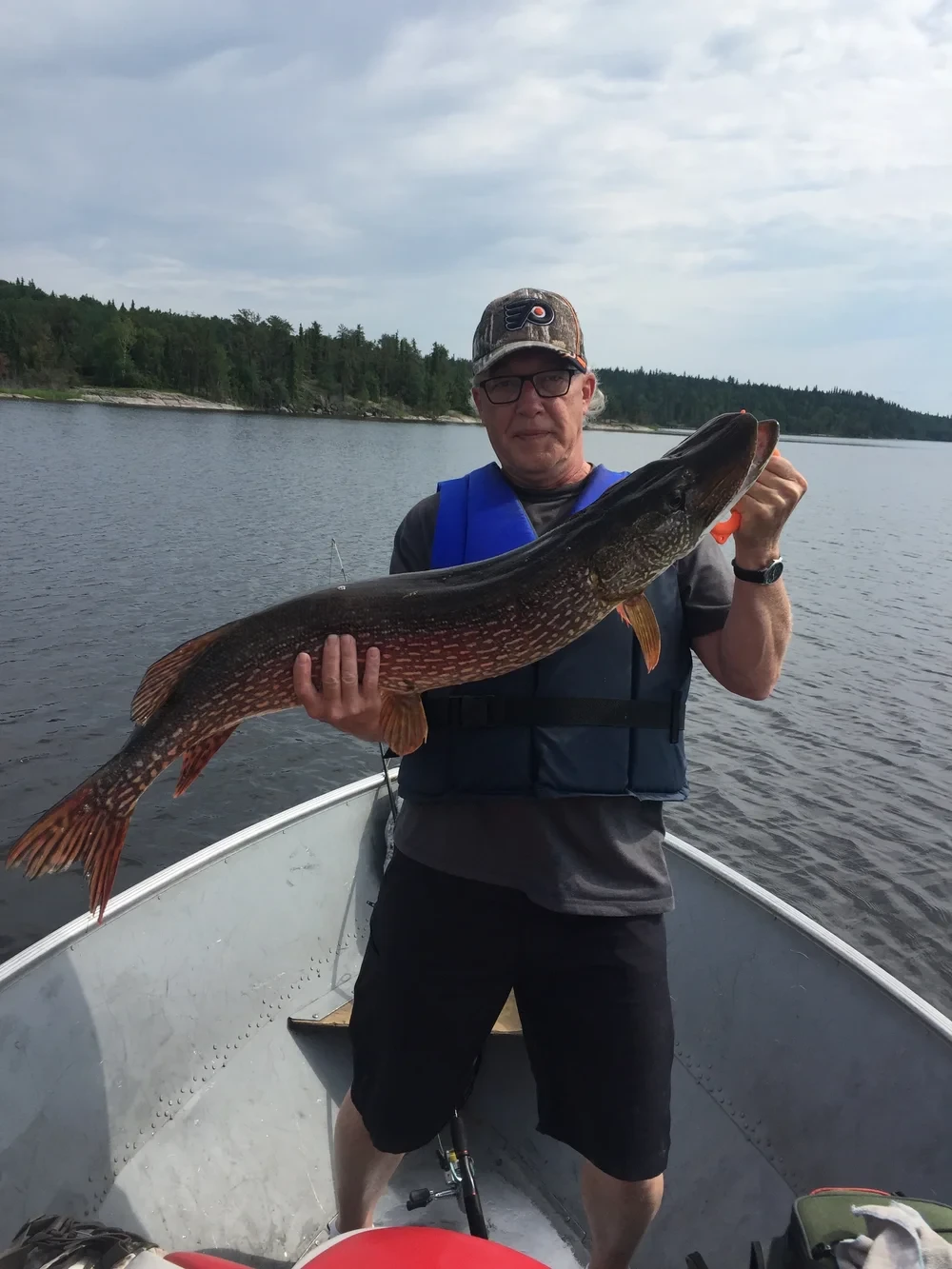 Man and girl holding caught pike fish, Black Bear Island Lodge