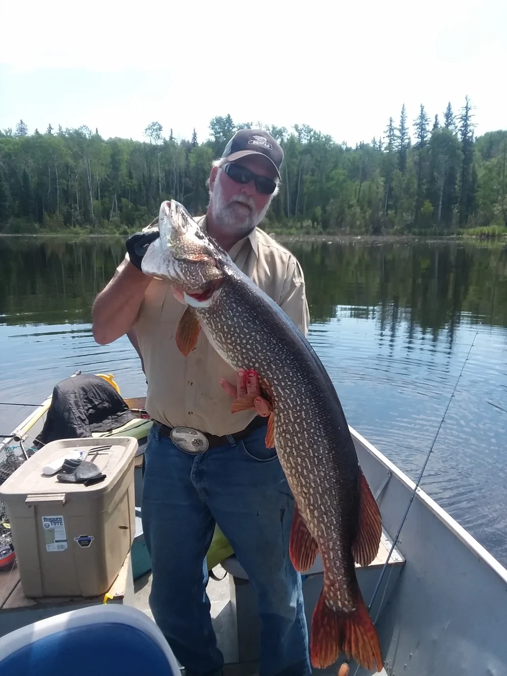 Girl holding caught fish on boat, Black Bear Island Lodge