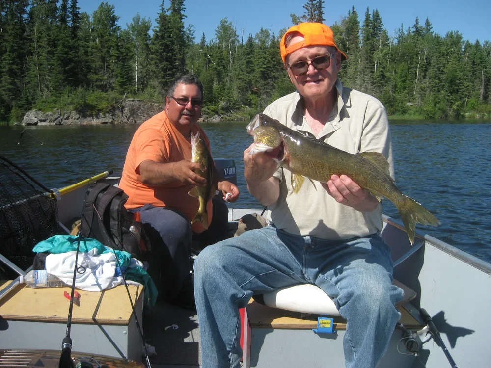 Man holding a large pike in a boat, wilderness backdrop