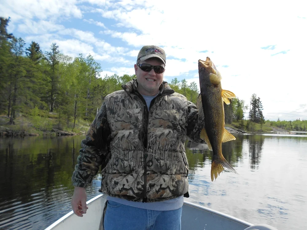 Angler with a trophy pike, wilderness setting