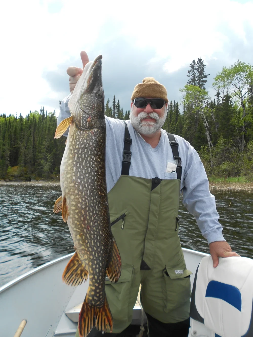 Man holding a large pike, sunny day on the Churchill River