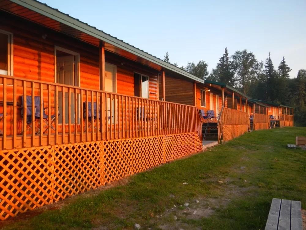 Lodge cabins with covered porch and railings glowing in golden evening light