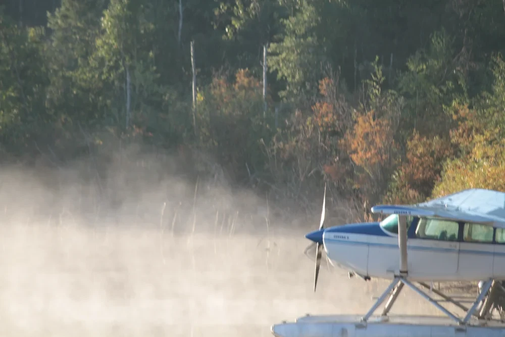 Floatplane on a misty lake dock surrounded by autumn foliage