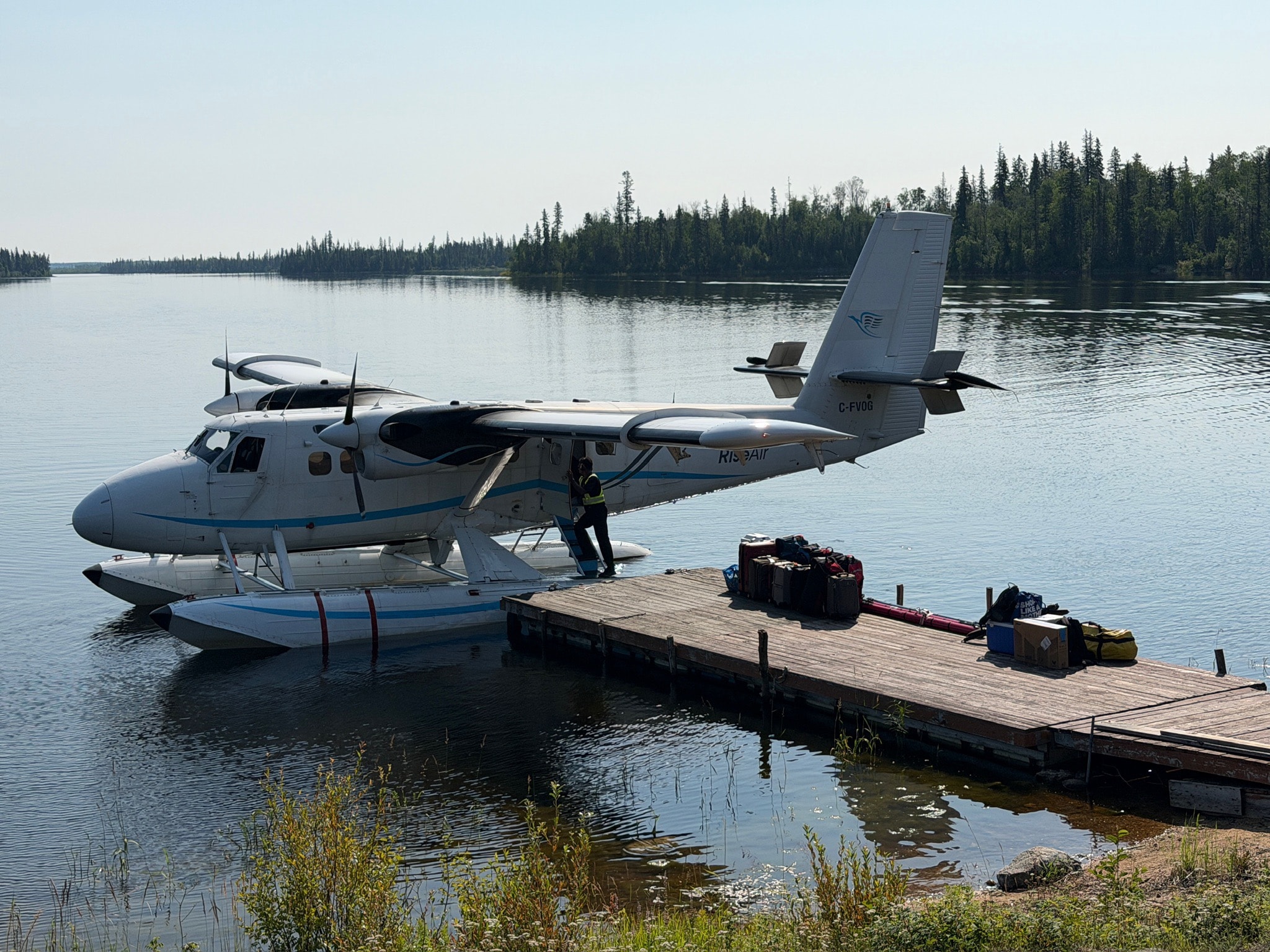 Twin Otter floatplane loading at remote wilderness dock