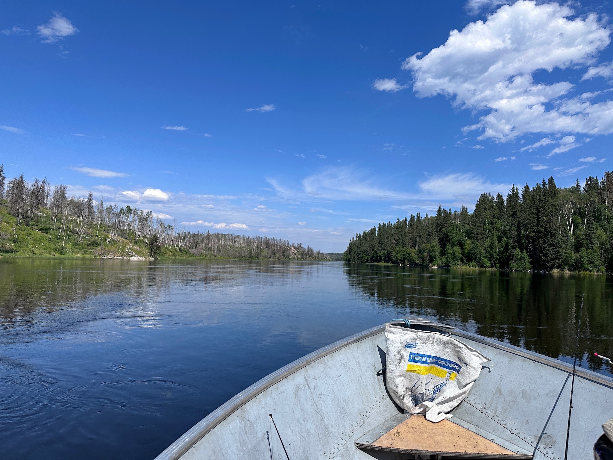 View from the bow of a fishing boat on a calm boreal river