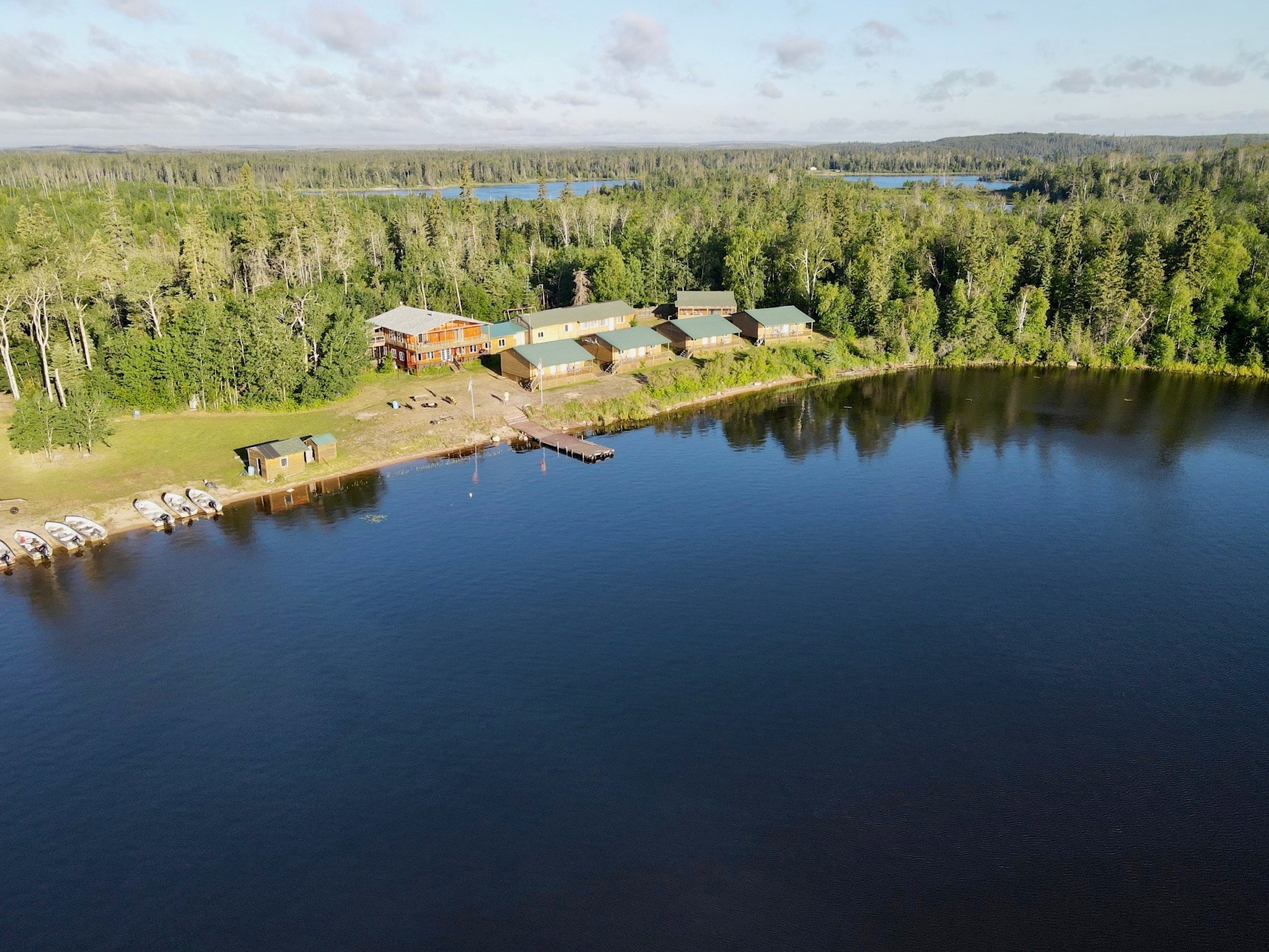 Aerial view of Black Bear Island Lodge cabins and dock on a calm boreal lake