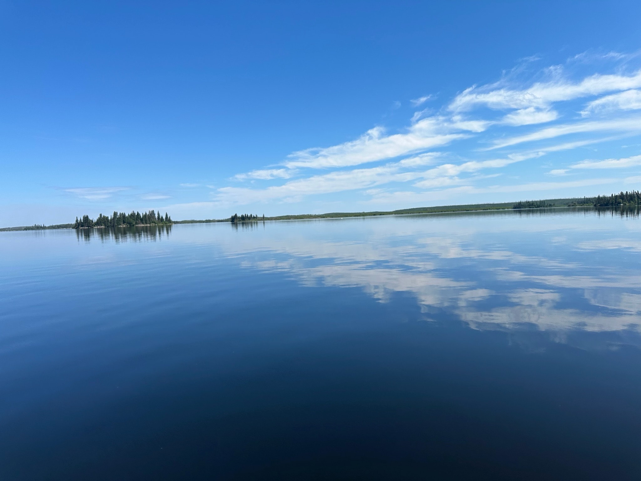 Glass-calm lake with clouds perfectly reflected on the water surface