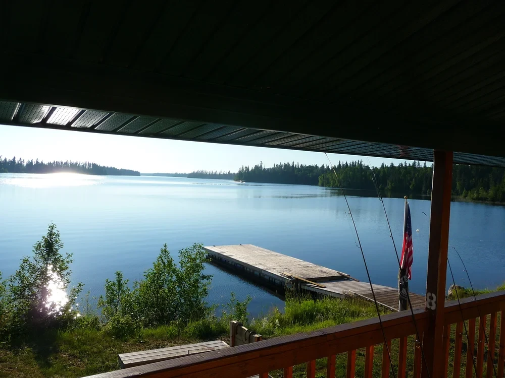 View from the cabin porch over the dock and lake with fishing rods
